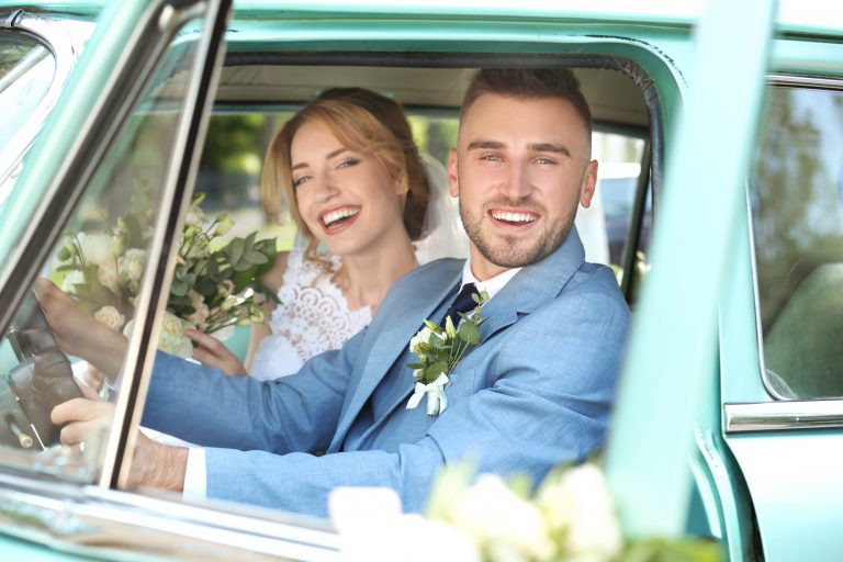 Happy wedding couple in car