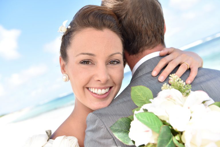 Bride embracing her groom at the beach