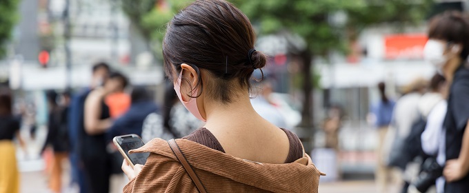 待ち合わせでスマートフォンを見る若い女性