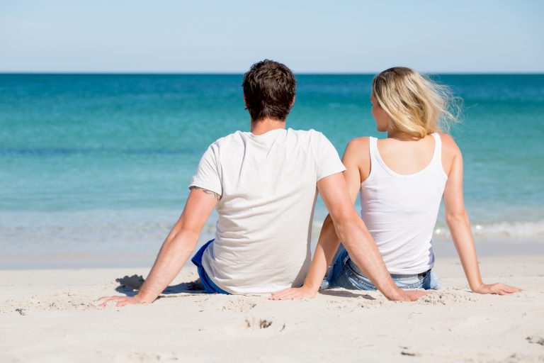 Romantic young couple sitting on the beach